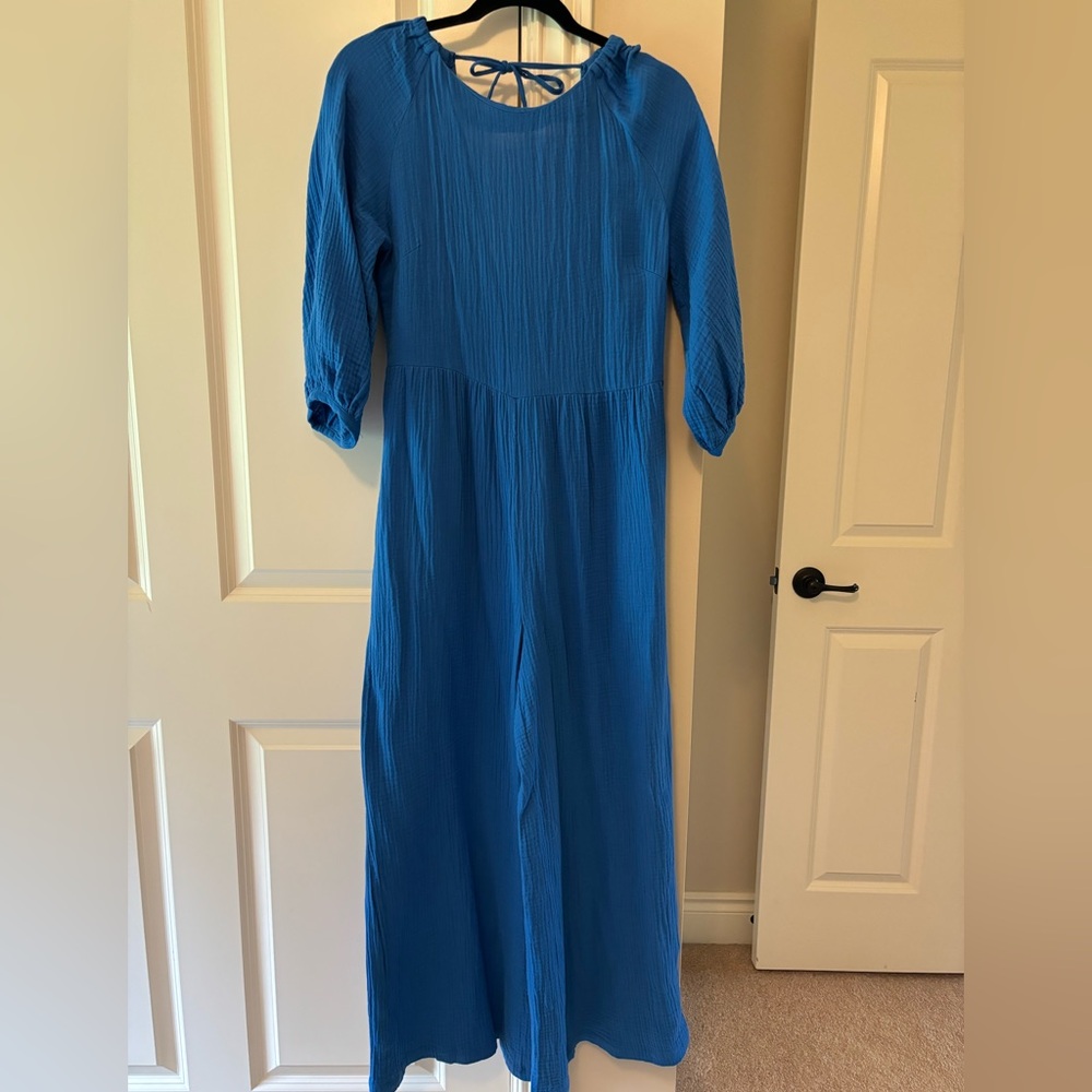 Blue jumpsuit with scoop back and tie at the top and 3/4 length sleeves